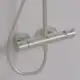 Duschsystem mit zwei Reglern und einem Handbrauseanschluss, montiert an einer Wand. Das Design ist in Matt-Silber gehalten. Hersteller ist Ideal Standard.